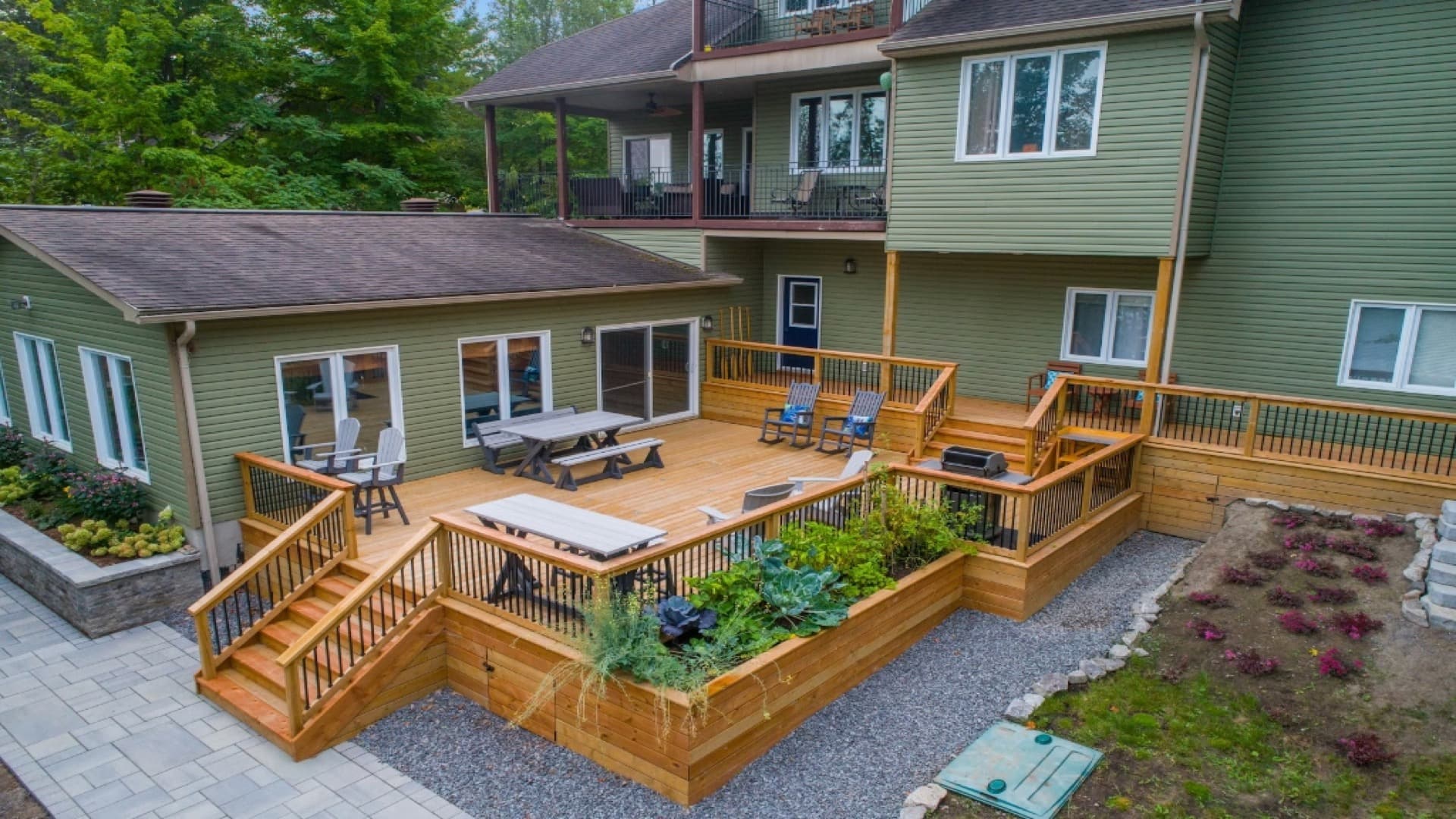 Multi-level wooden deck with outdoor furniture and landscaping